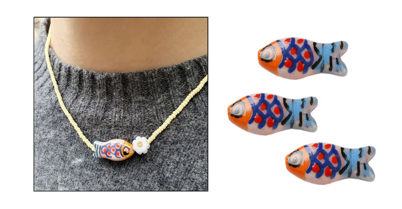 Perlhalsk�de med fisk af keramik